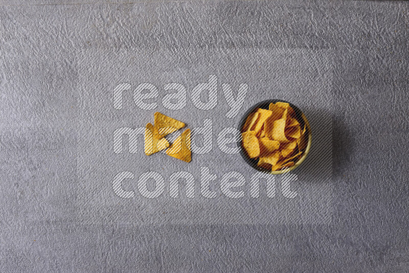 Assorted snacks in pottery bowls on grey background