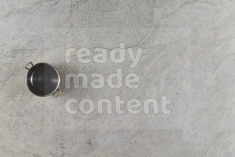 A small copper pot on grey marble background