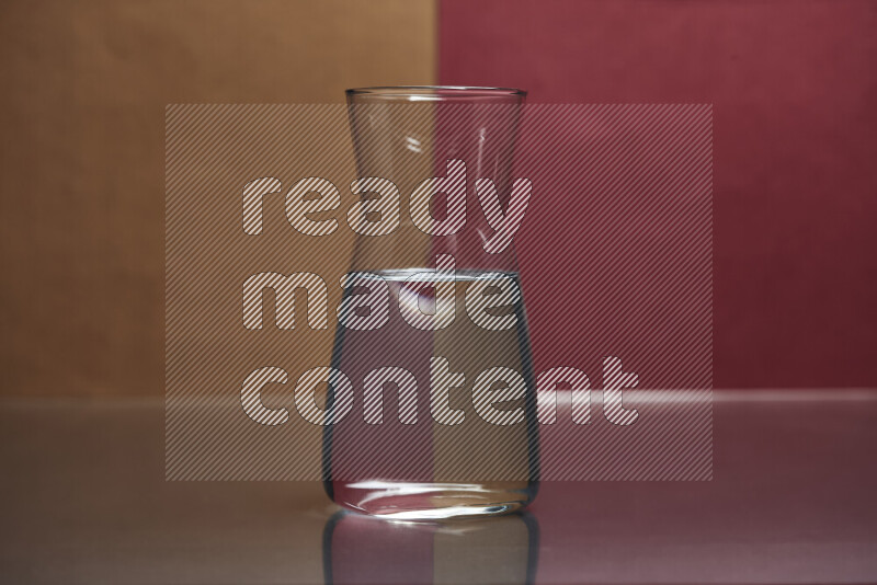 The image features a clear glassware filled with water, set against brown and dark red background