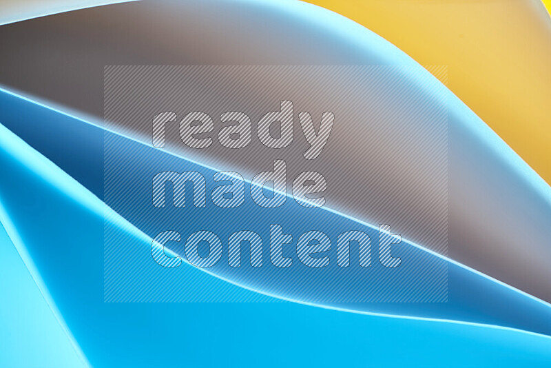 This image showcases an abstract paper art composition with paper curves in blue and yellow gradients created by colored light