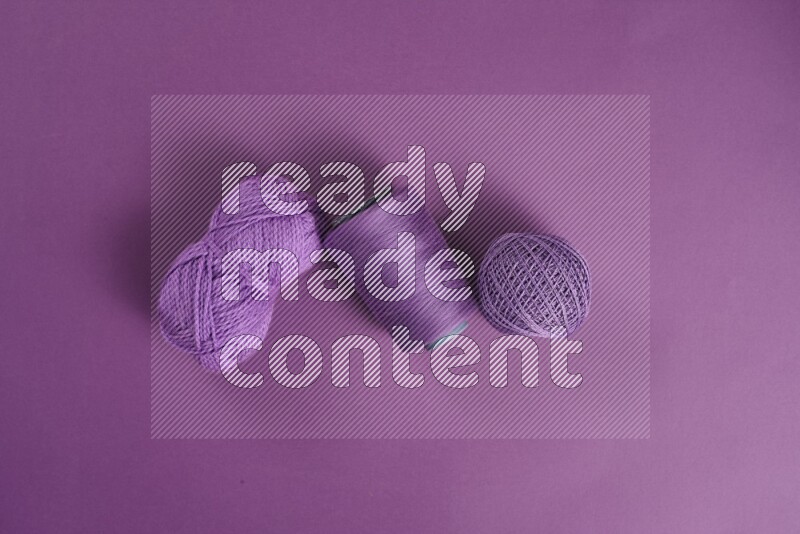 A purple collection of sewing and tailoring tools arranged on a purple background