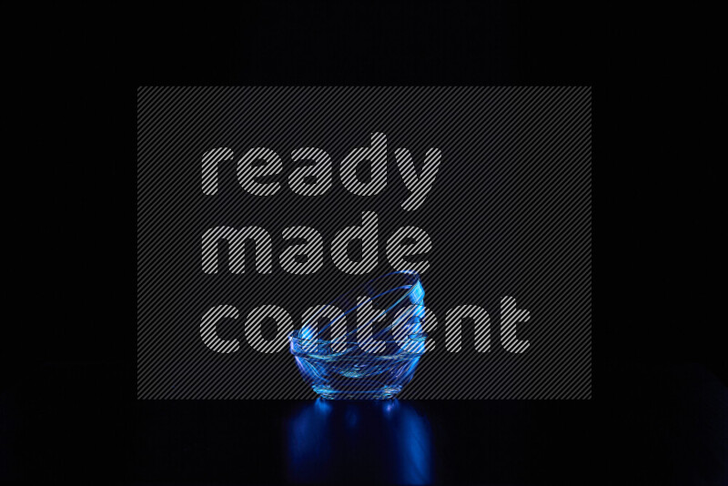 Glassware with rim light in blue against black background