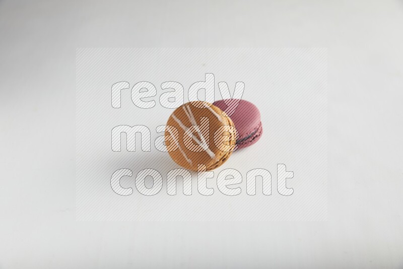 45º Shot of of two assorted Brown Irish Cream, and Red Cherry macarons on white background