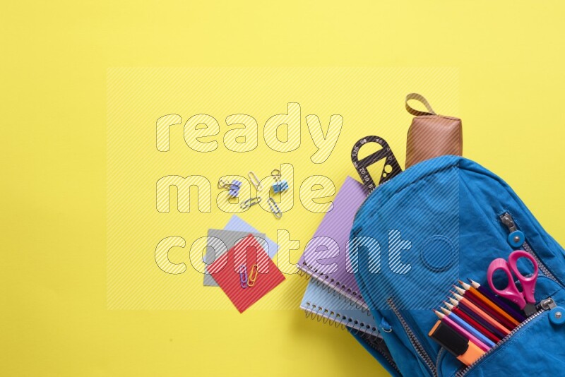 A blue school bag placed on yellow background