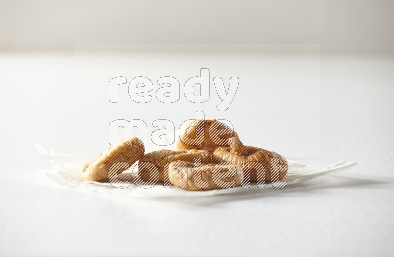 Dried figs on a crumpled piece of paper on a white background in different angles