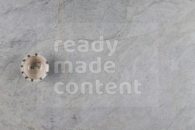 صحن فخاري مزخرف على خلفية من الرخام الرمادي