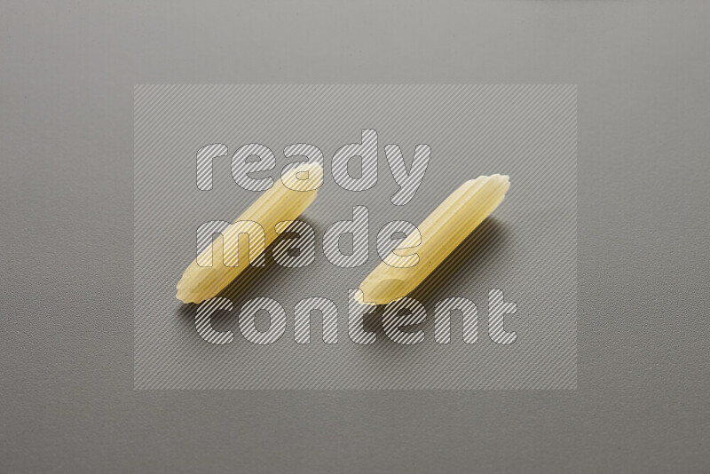 Mini penne pasta on grey background