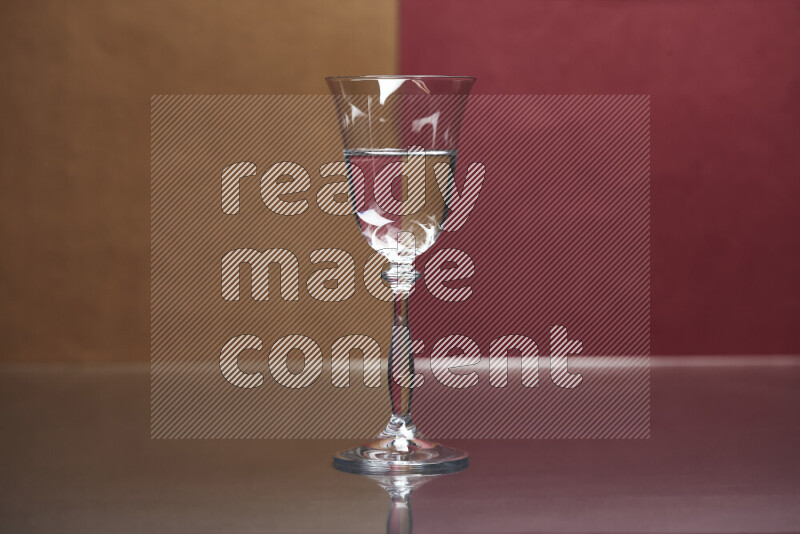 The image features a clear glassware filled with water, set against brown and dark red background