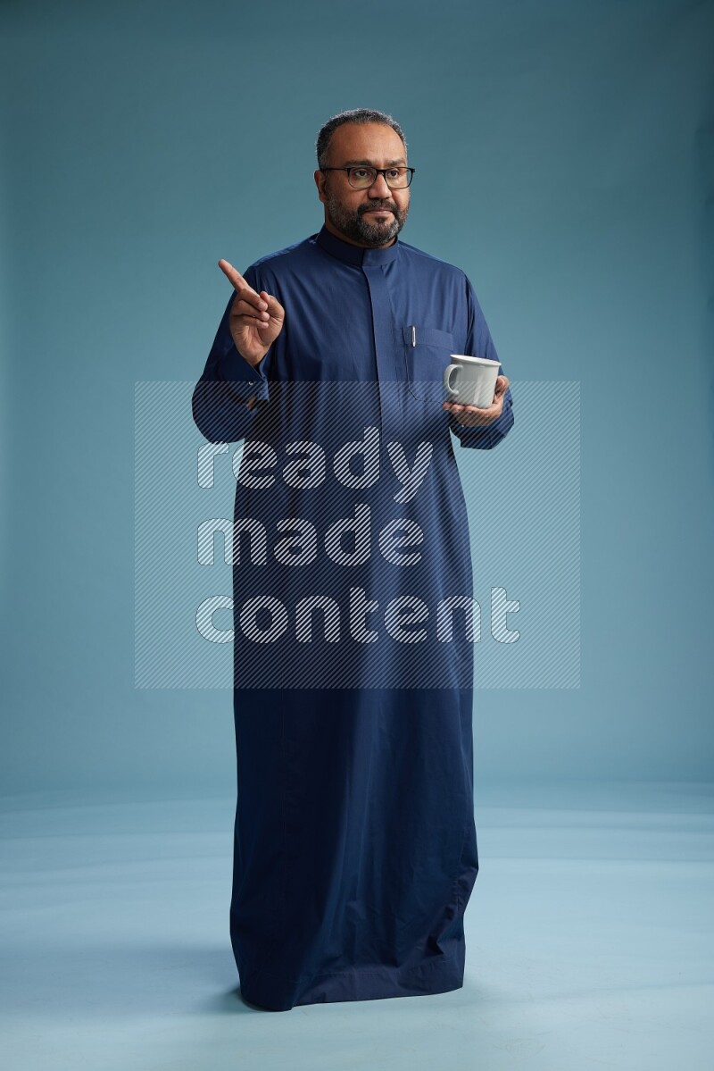 Saudi Man without shimag Standing drinking coffee on blue background