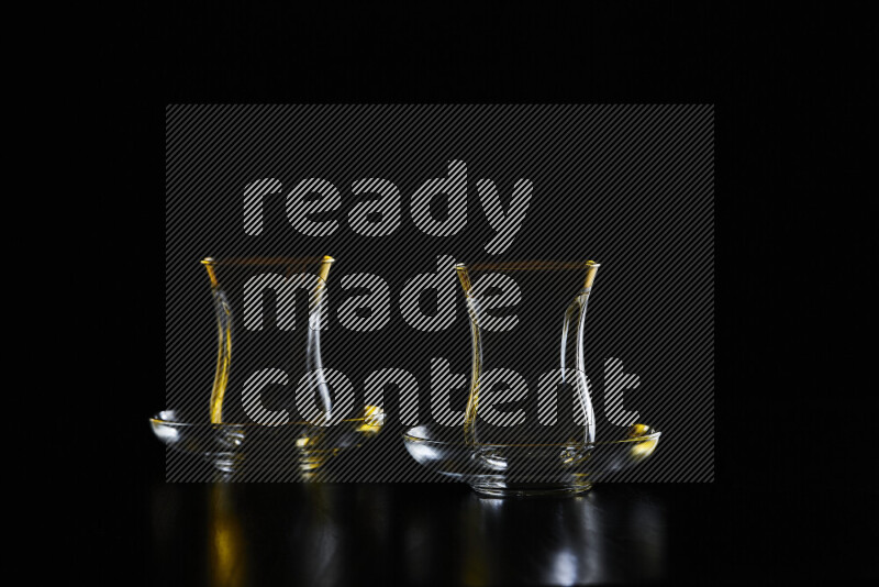 Glassware with rim light in yellow and white against black background