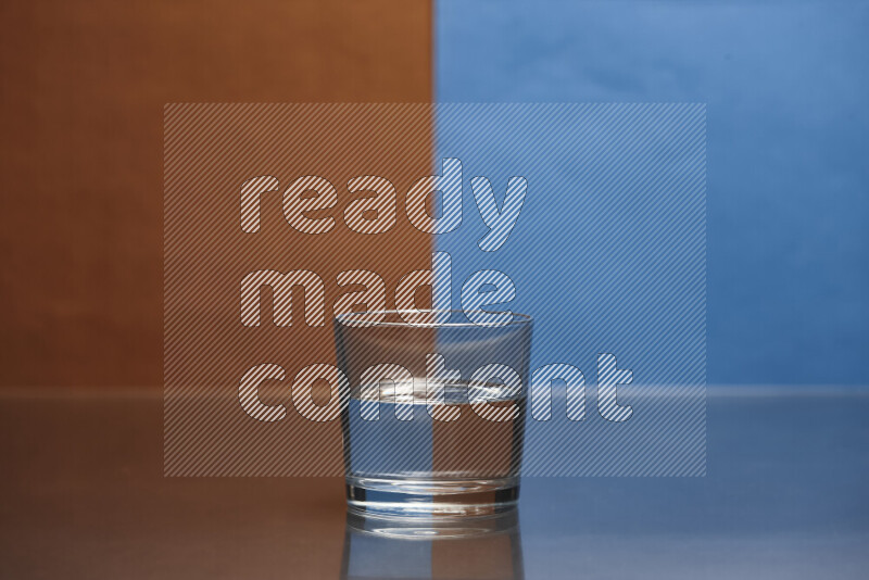 تظهر الصورة أواني زجاجية ممتلئة بالماء موضوعة على خلفية من اللونين البني والأزرق