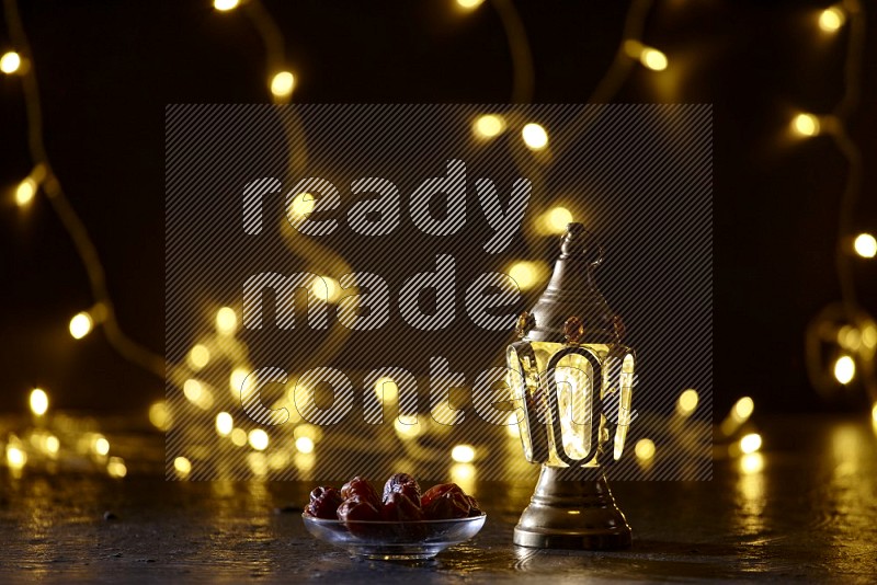 A golden lantern with fairy light in a dark setup