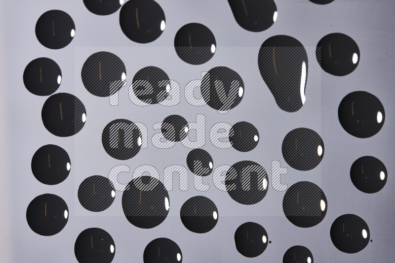 Close-ups of abstract black paint droplets on the surface