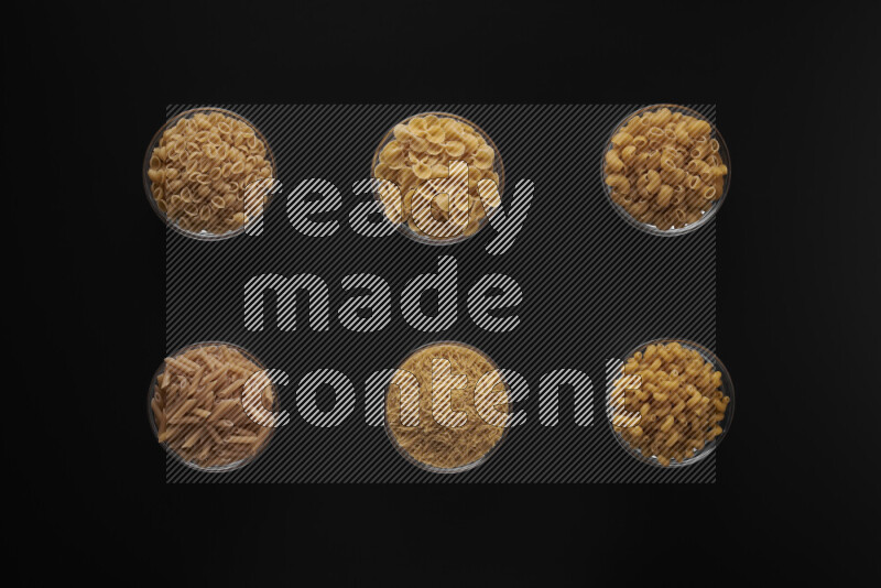 أنواع مختلفة من المعكرونة في أوعية زجاجية علي خلفية سوداء