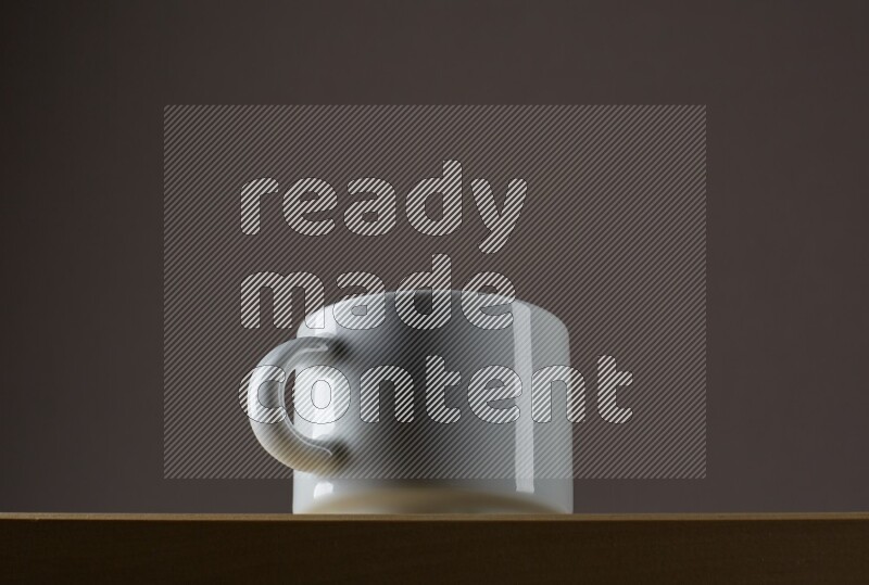 Low angle shot of a white cup on grey background