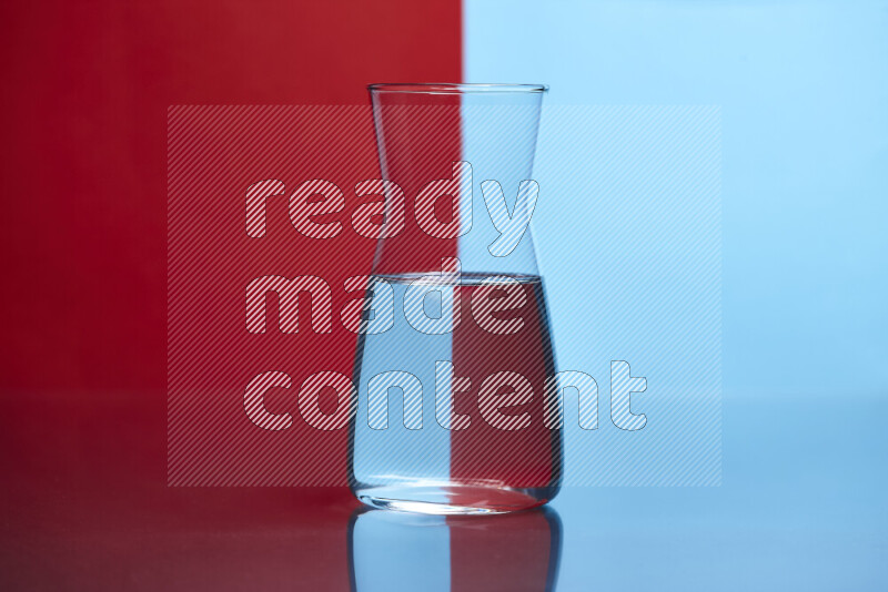 The image features a clear glassware filled with water, set against red and light blue background