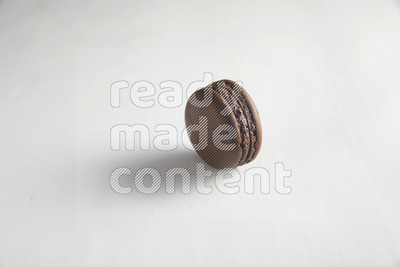 45º Shot of Brown Dark Chocolate macaron on white background