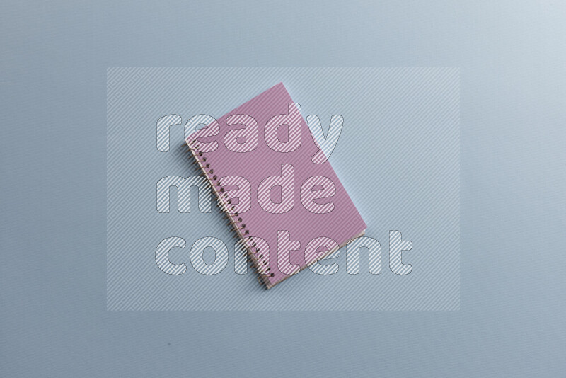 A purple notebook with different school supplies on blue background