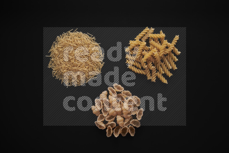 Different pasta types in bunches on black background