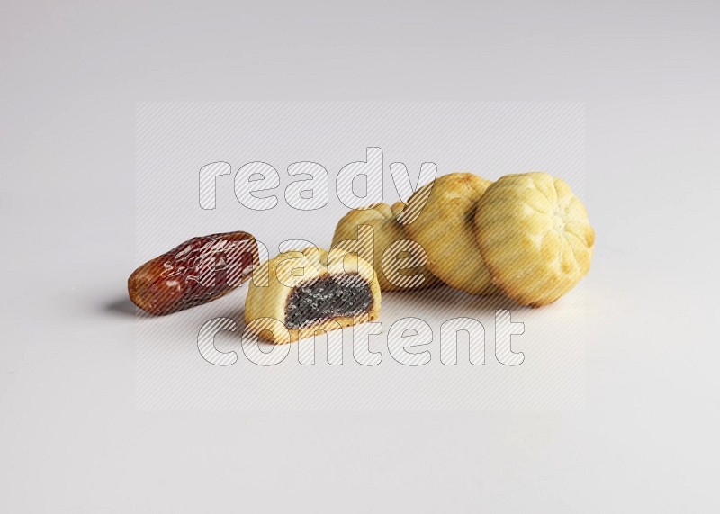 Four Pieces of Maamoul filled with date one of them is cut direct on white background