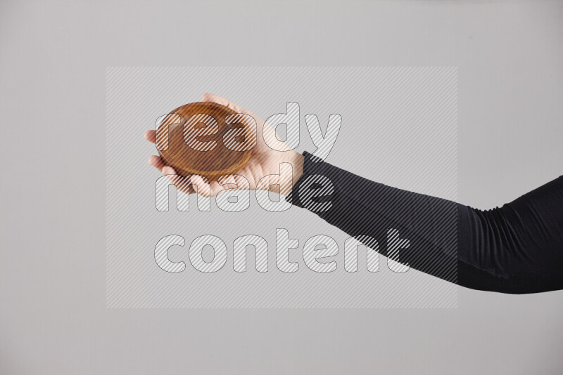 امرأة ترتدي عباءة سوداء تحمل أدوات خشبية مختلفة في أوضاع متعددة