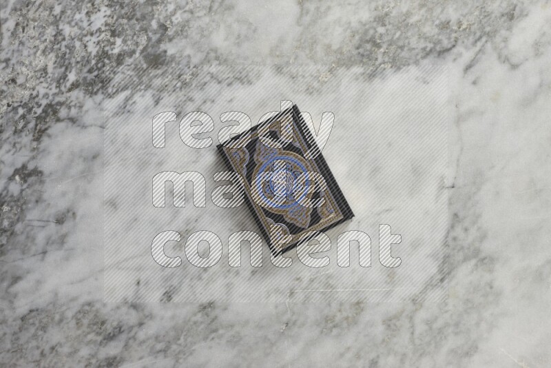 Quran with a prayer beads on grey marble background
