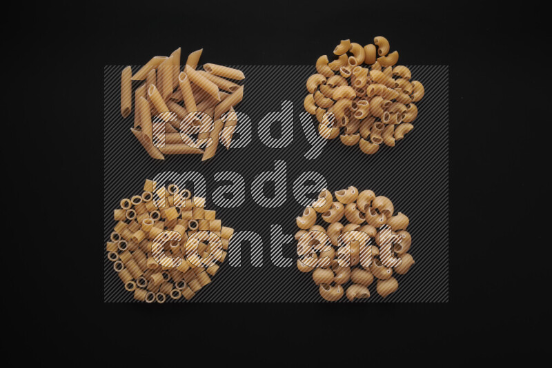 Different pasta types in bunches on black background