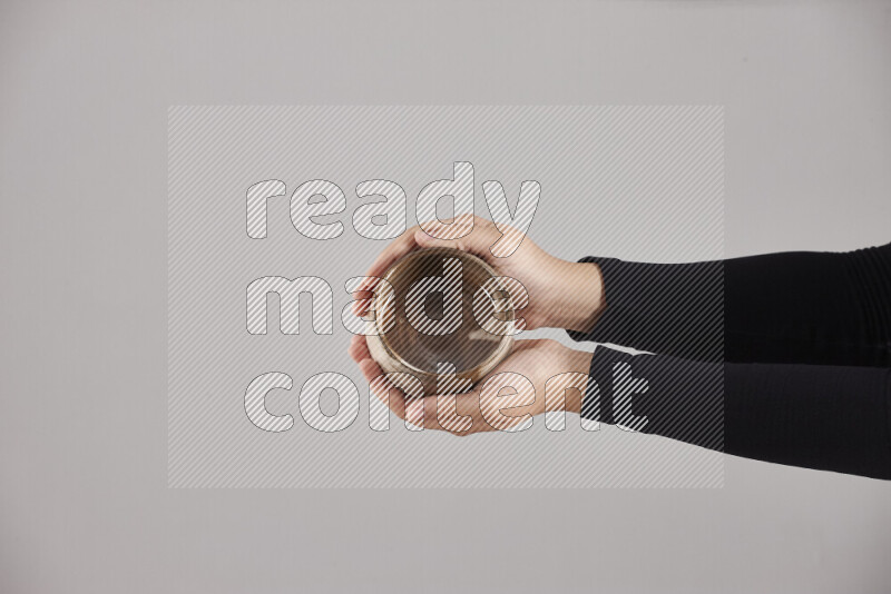 A woman in black abaya holding different pottery essentials in different positions