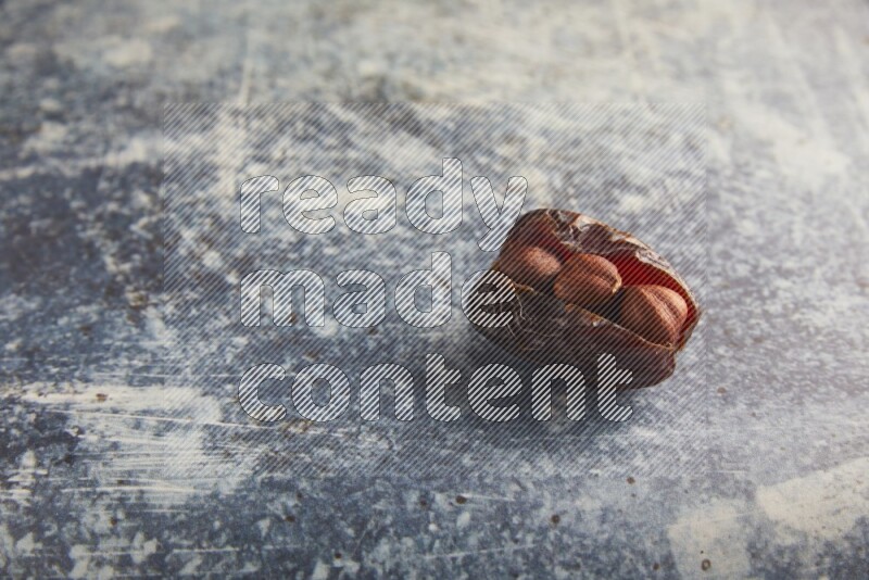 hazelnuts stuffed majdoul date on a rustic blue background