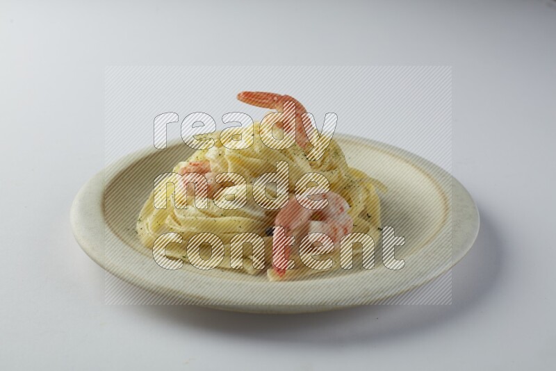 Fettuccini white sauce pasta with shrimp in a white plate on a white background