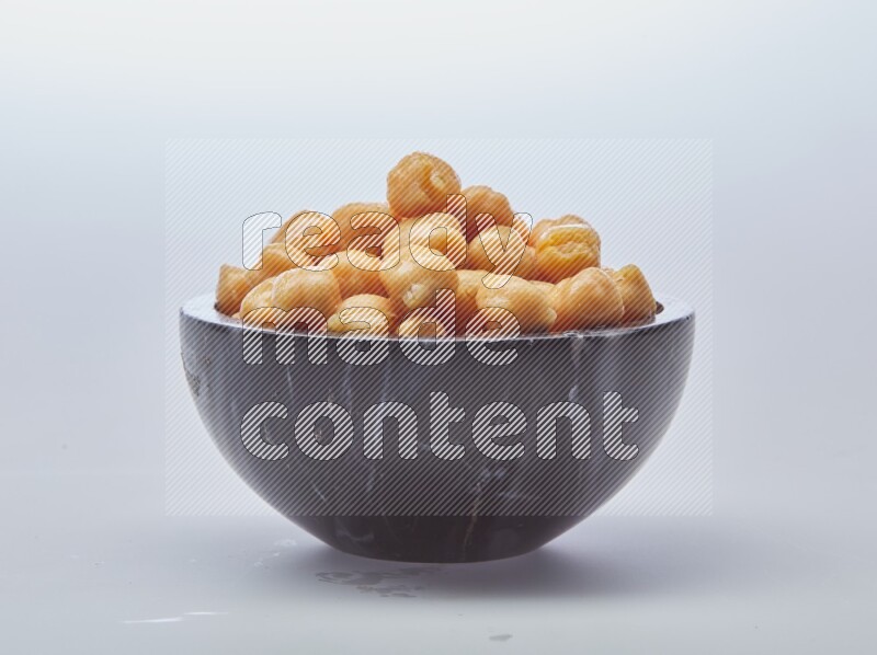 Close up shot of boiled chickpeas in a container on white background