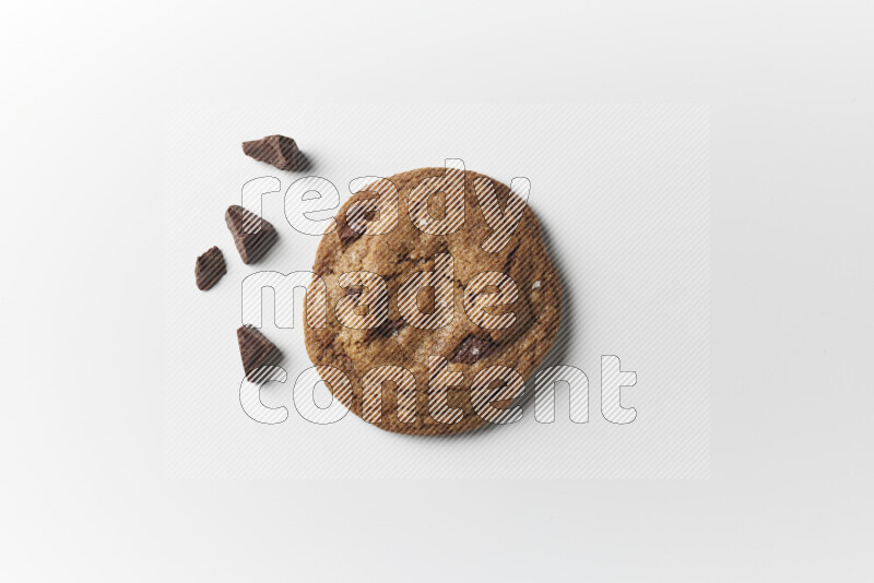 A single chocolate chips cookie with chocolate beside it on a white background