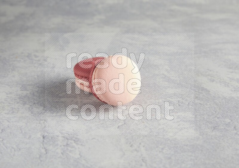 45º Shot of two Pink Litchi Raspberry macarons  on white  marble background
