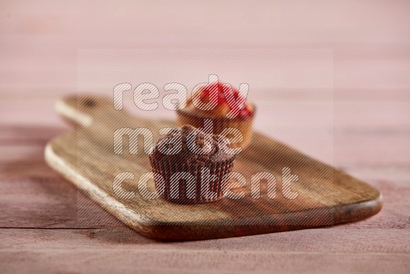 Chocolate mini cupcake topped with chocolate chips on a wooden board