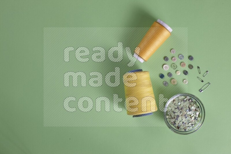 مجموعة من أدوات الخياطة والتفصيل على خلفية خضراء