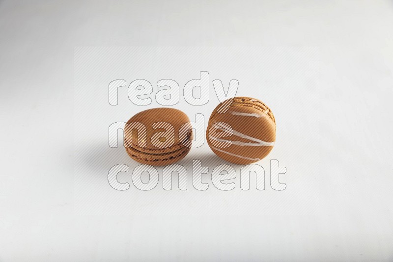 45º Shot of of two assorted Brown Irish Cream, and Brown Coffee macarons  on white background