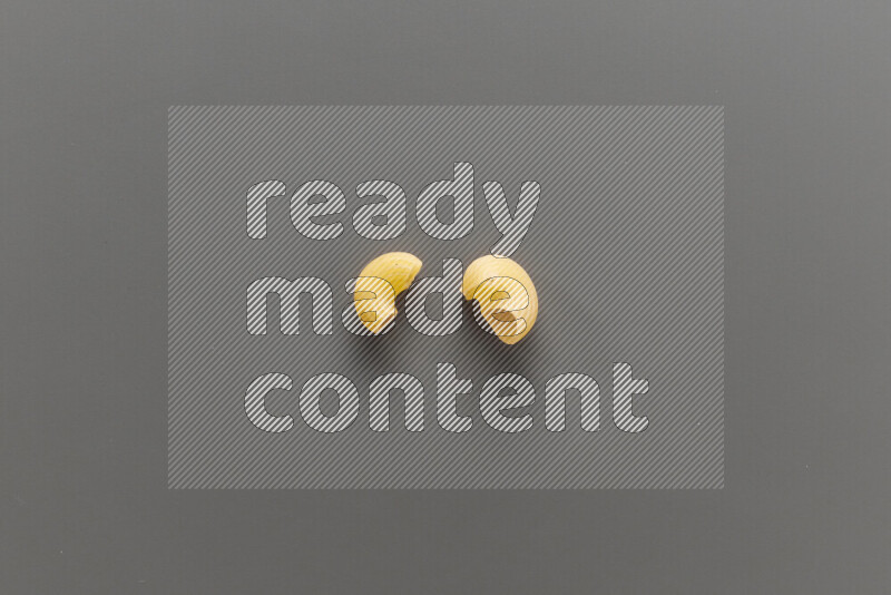 Elbow pasta with other types of pasta on grey background