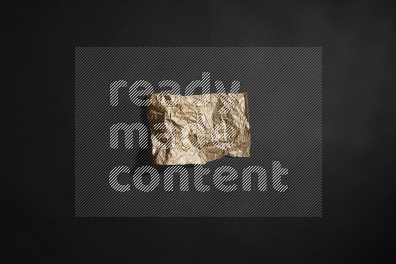 Crumpled craft paper on black background