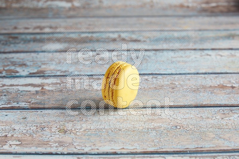 45º Shot of Yellow Lemon macaron on light blue wooden background