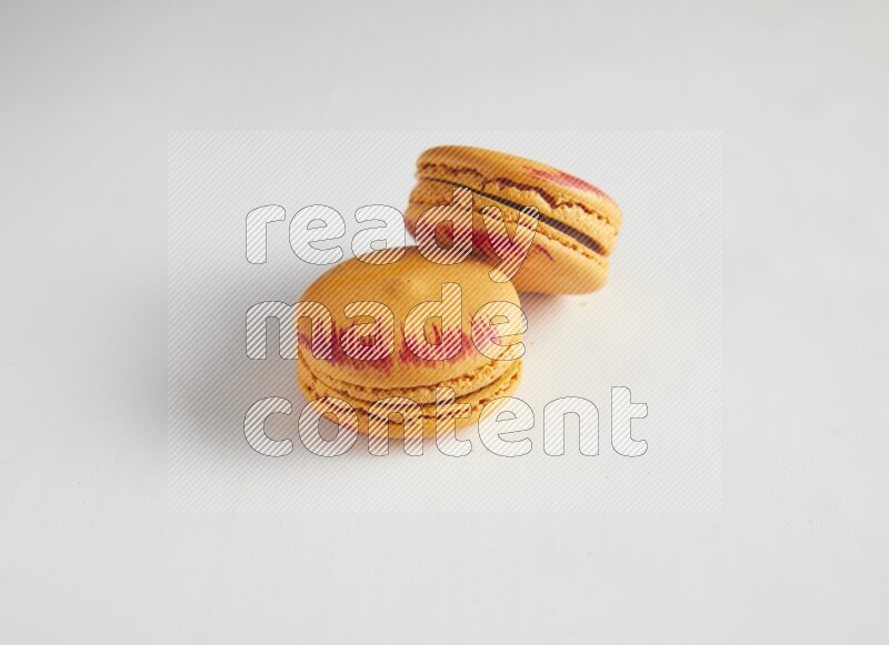 45º Shot of two orange Exotic macarons on white background