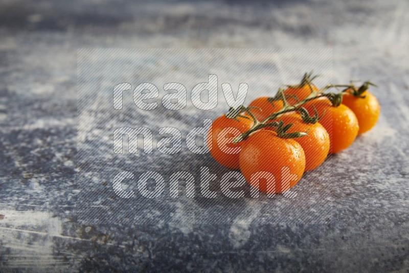 Orange cherry tomato vein on a textured rusty blue background 45 degree