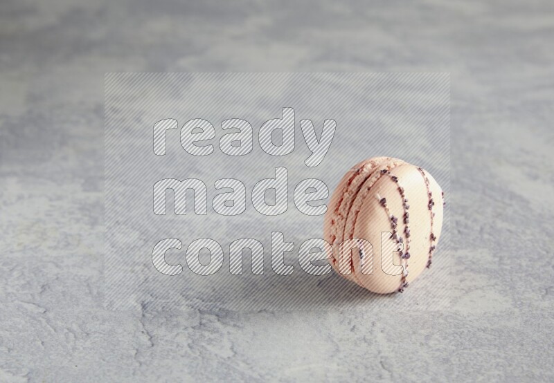 45º Shot of pink orange blossom macaron on white  marble background