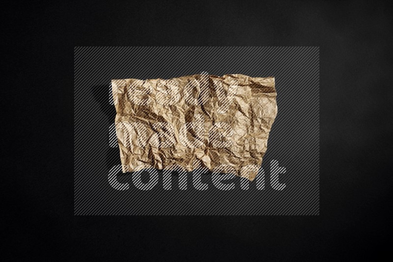 Crumpled craft paper on black background