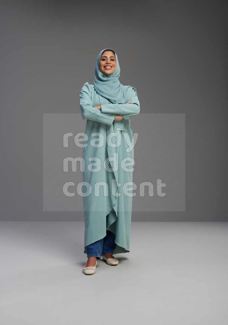 Saudi Woman wearing Abaya standing with crossed arms on Gray background