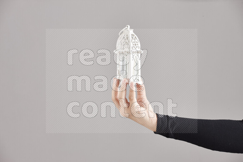 A woman in black abaya holding different ramadan lanterns in different positions
