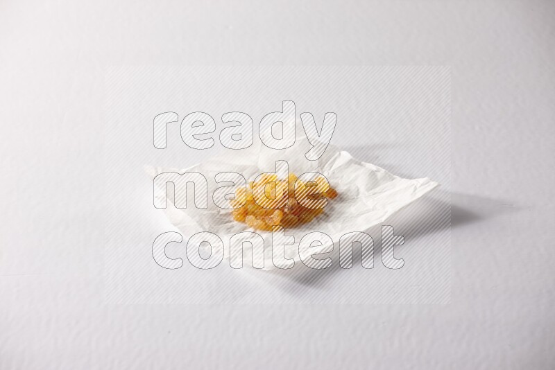 Raisins on a crumpled piece of paper on a white background in different angles