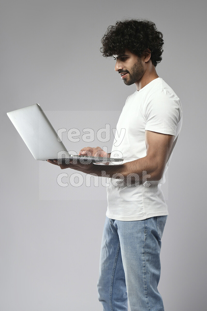 رجل يرتدي ملابس كاجوال يعمل علي لاب توب علي خلفية بيضاء