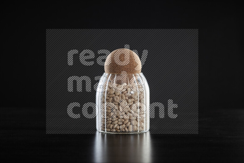 Lupin Beans in a glass jar on black background