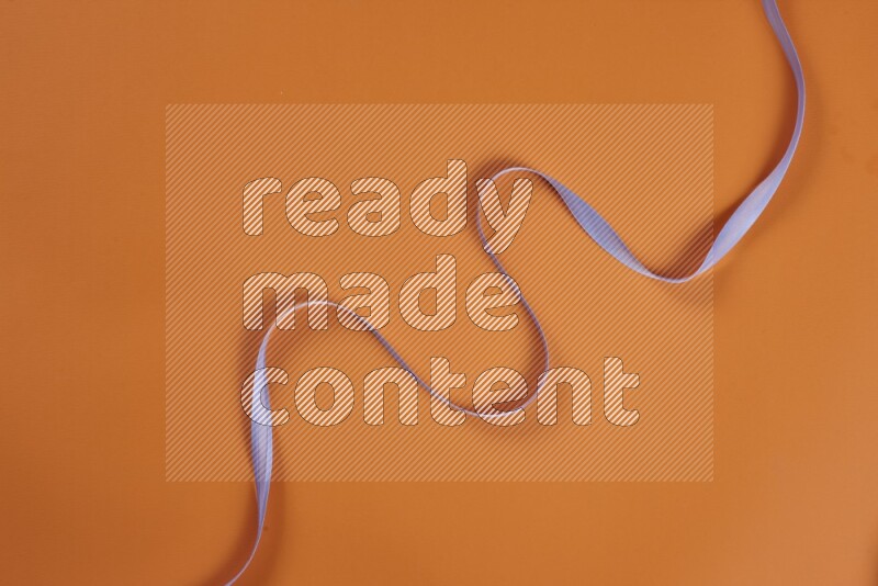 A purple collection of sewing and tailoring tools arranged on a orange background