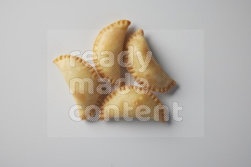 Four fried sambosa from a top angle on a white background